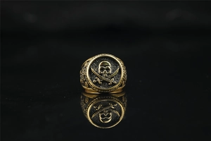 Macro detail of vintage gold pirate skull and crossbones emblem on a steel biker ring