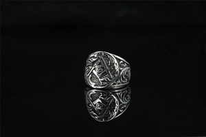 Macro view of vintage Masonic ring with silver finish and detailed G symbol engraving