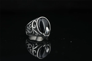 Detailed view of retro steel ring featuring a black oval gemstone and hawk claw carving