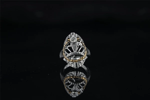 Vue macro de la bague chevalière vintage bicolore avec motif couronne et pierre zircon