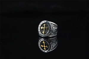 Vue macro d'une bague croix vintage avec émail noir et gravures de style punk rock
