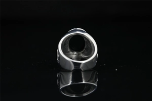 Detailed back view of vintage silver steel ring with black oval stone inlay on black background