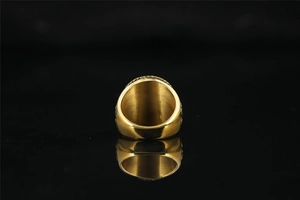 Macro detail of polished gold-finished pirate skull signet ring with smooth inner surface