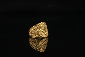 Macro shot of gold Masonic ring detailing the compass G symbol and engraved relief patterns