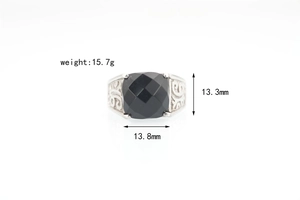 Detailed view of vintage steel ring with black gemstone and engraved scroll patterns