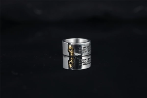 Detail of vintage bicolor skull ring showing engraved inspirational text and metallic texture