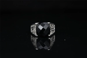 Detailed close-up of retro silver ring featuring black gemstone and ornate side carvings