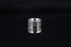 Detail of silver skull ring with engraved quote on polished stainless steel band