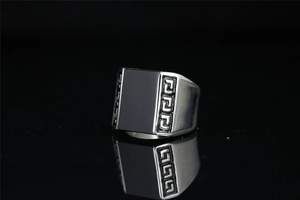 Detailed view of silver titanium steel ring with black inlay and Greek meander pattern