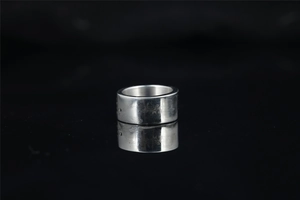 Macro view of wide silver titanium steel ring featuring detailed side engravings