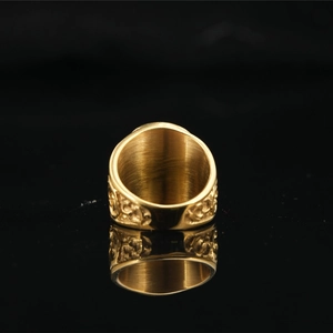 Vintage gold Freemason ring with embossed floral patterns on a black mirror surface