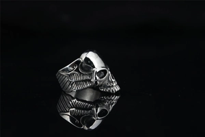 Detailed view of skull and wing carvings on a vintage stainless steel gothic ring