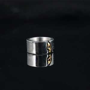 Two-tone gothic skull ring in silver and gold stainless steel with mirror reflection