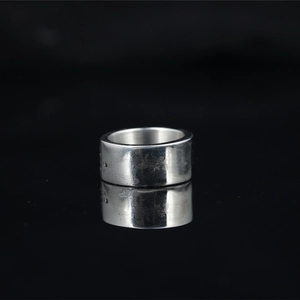 Polished silver skull style wide titanium steel ring with engraved letters on black background