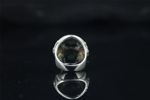 Macro-opname van zilveren punk schedelring met hol reliëf en metalen textuur
