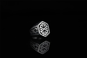 Macro shot of vintage black titanium steel ring with hexagon totem and relief patterns