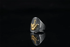 Détail macro d'une bague punk rétro pour homme avec relief de signe de main doré sur bouclier