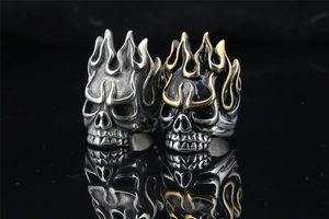 Detail of vintage punk skull flame rings in antique silver and black gold finishes