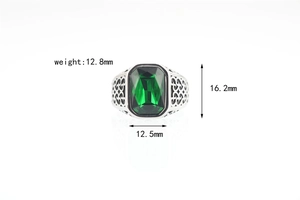 Detail view of vintage emerald-cut green gemstone ring with ornate silver-toned engraving