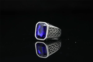Macro shot of vintage titanium steel ring featuring a blue gemstone and filigree details