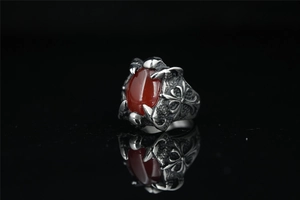 Macro detail of gothic dragon claw ring featuring a large oval red gemstone inlay
