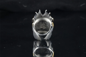 Detail of silver crown ring with flame jagged top and gold decorative side accents