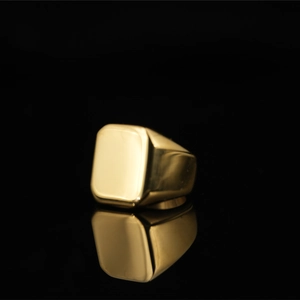 Polierter goldener Siegelring für Herren im Punk-Stil auf schwarzer, reflektierender Fläche