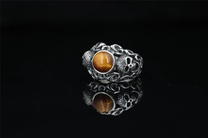 Macro shot of tiger eye stone ring with vintage silver skull and baroque carvings