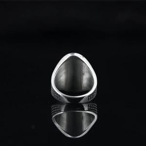 Bague punk hip-hop en acier titane avec geste de la main sur fond noir réfléchissant
