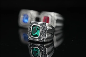 Détail d'une bague vintage en acier titane avec zircon vert et reliefs floraux ciselés