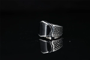 Macro shot of men's titanium steel ring with black enamel inlay and textured carving