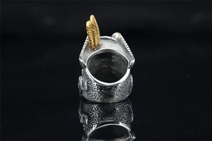 Detail of silver hammered stainless steel ring featuring a gold feather relief carving