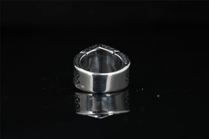 Macro shot of silver titanium steel ring with vintage embossed patterns on mirror stand