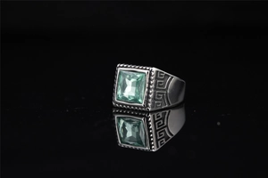 Vue détaillée d'une bague rétro en acier avec pierre verte carrée et motifs gravés fins