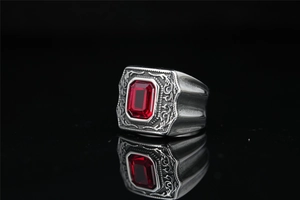 Macro d'une bague vintage en acier titane avec pierre rouge et gravures florales