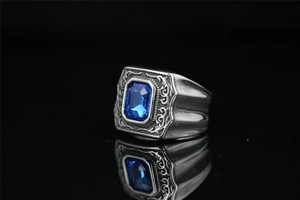 Détail de la bague en acier vintage avec pierre bleue et gravures de vignes