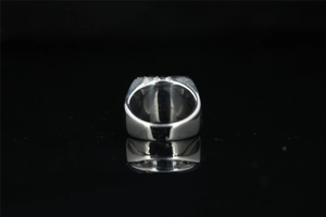 Détail d'une bague en acier titane argenté poli avec finition miroir sur noir