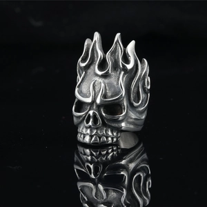 Gothic flame skull ring in vintage stainless steel with mirrored reflection on black background