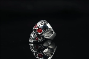 Macro detail of gothic skull ring in silver metal with ruby red crystal stone accents