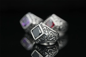 Macro shot of vintage titanium steel rings with square red, purple, and black gemstones