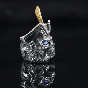 Vintage steel pirate skull ring for men featuring golden feather and blue stone eyes