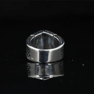 Men's titanium steel ring with unique geometric shape and engraved texture on black background