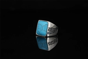 Detailed macro view of men's titanium ring featuring a rectangular turquoise and Greek key pattern