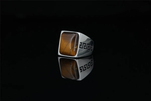 Detail of square tiger eye stone signet ring with Greek key pattern on stainless steel