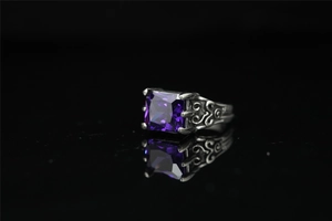 Dettaglio anello vintage in acciaio al titanio con pietra quadrata viola e intagli