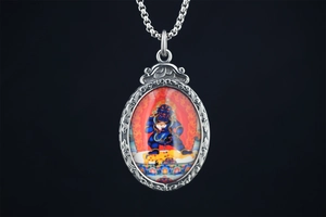 Gros plan sur un pendentif en acier titane avec divinité bouddhiste colorée