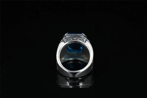 Vista macro di un anello da uomo vintage in acciaio con grande gemma blu e incisioni
