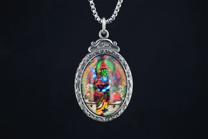 Détail du cadre métallique vintage et du pendentif coloré de divinité bouddhiste