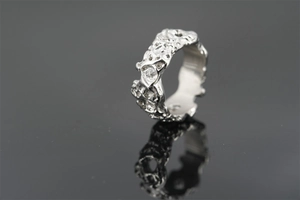Macro detail of irregular lava texture and liquid metal finish on titanium steel ring