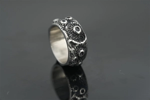 Macro shot of punk style steel ring with realistic moon crater texture and black finish